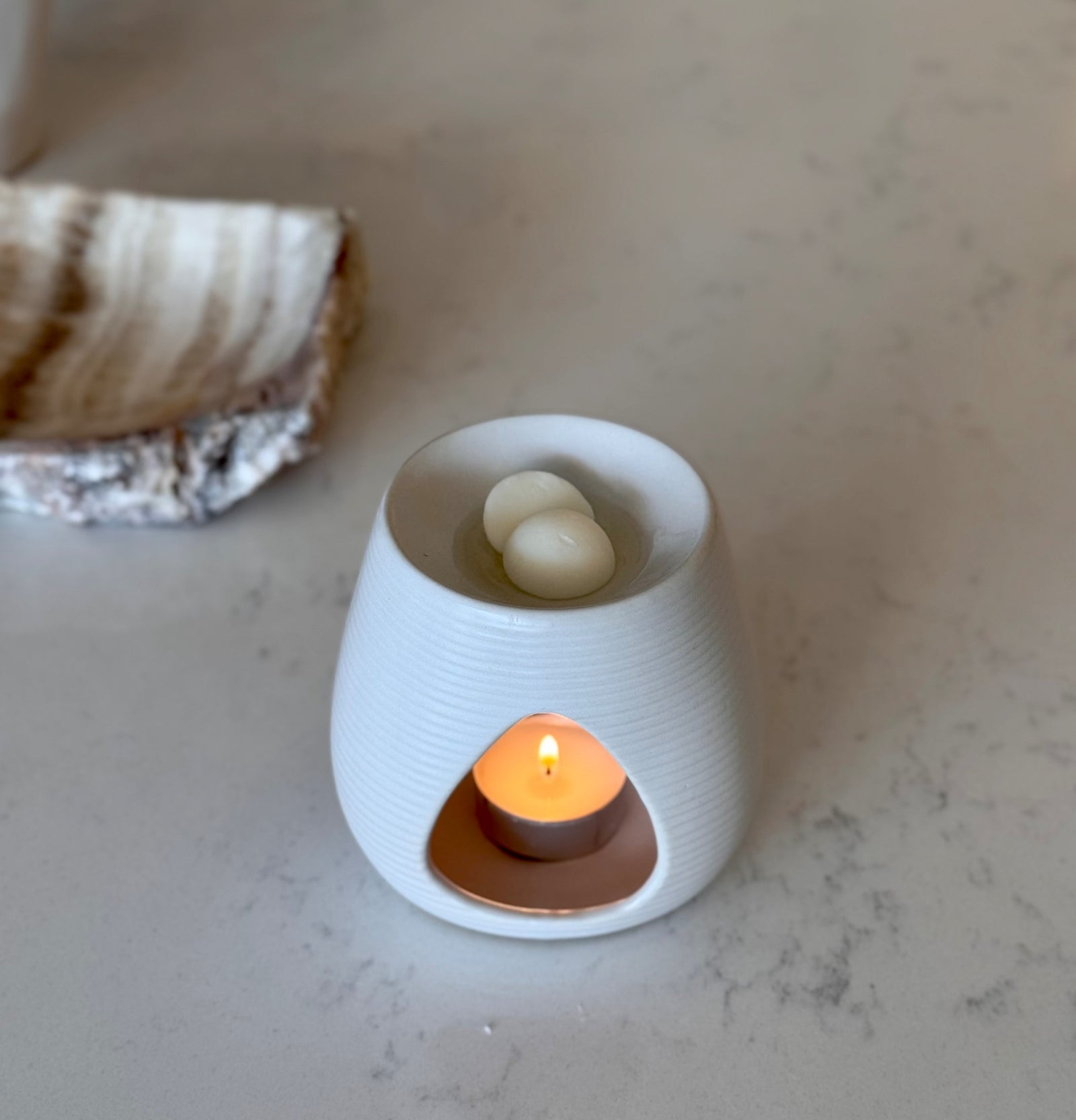 White ceramic wax melt burner with textured surface on a light background